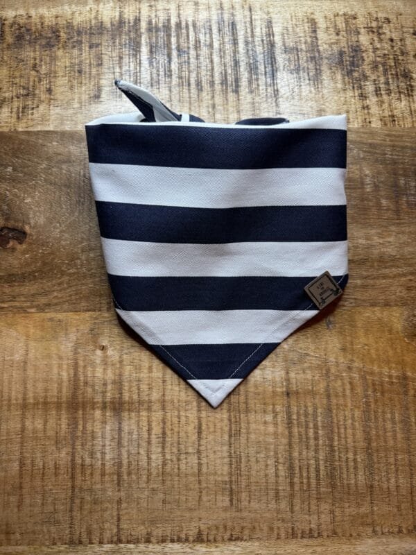 Bandana Marine (horizontaal) Met deze Bandana Marine (horizontaal) van A Lot for Doodles ziet jouw hond er uit om door een ringetje te halen. De bandana is handgemaakt en van 100% katoen. De Bandana is door de driehoekige vorm gemakkelijk te knopen een aan te passen in elke gewenste grootte. De bandana is geschikt voor zowel kleine als grote honden met een nekomtrek van maximaal 50 cm. Voor kleine honden kun je de bandana aan de bovenzijde een paar keer omvouwen, zodat hij als gegoten zit :) Productspecificatie Bandana Marine (horizontaal) Materiaal: Katoen Vorm: Driehoek, aan beide zijden bedrukt. Kleur: Zwart met wit Merk: Handmade by A Lot for Doodles Maat: Nekomtrek maximaal 50 cm Wasvoorschrift: 30 graden Pinwheels, Bow Tie's en Bandana's voor honden kopen Bij A Lot for Doodles vind je een mooie selectie aan pinwheels, strikjes en bandana's voor honden. Zo kan elke hond goed gestyled de straat op Bandana's en strikjes voor honden Kleding maakt de hond. De Bandana's van A Lot for Doodles of de  strikjes en bandana's van Huxley and Kent zijn een echte eyecather. Jouw hond ziet er met de Banda's van A Lot for Doodles uit om door een ringetje te halen. De bandana's hebben verschillende designs zodat er altijd wel een passende bandana te vinden is voor jouw hond. Bekend van Instagram Als jij honden volgt via Instagram, dan kan het niet missen dat je wel eens de mooiste bandana's, strikjes en pinwheels voorbij hebt zien komen. Niet zo gek want de bandana's & strikjes zijn perfect voor een geweldige foto van jouw hond. Vergeet je A Lot for Doodles niet te taggen op Instagram? Bestel Bandana's en strikjes voor honden bij A Lot for Doodles Bestel je bandana's en strikjes voor jouw hond eenvoudig bij A Lot for Doodles. Of je nu een burberry design strik zoekt of een vrolijke bandana, met ons ruime assortiment wat uit voorraad leverbaar is zit er altijd een passende bandana of strik tussen. Ook voor het leukste (interactieve) hondenspeelgoed, shampoo's voor honden en lekkere hondensnacks kun je bij ons terecht. Heb je vragen over onze producten of advies nodig wat je het beste kunt bestellen? Neem gerust contact met ons op, we helpen je graag verder.