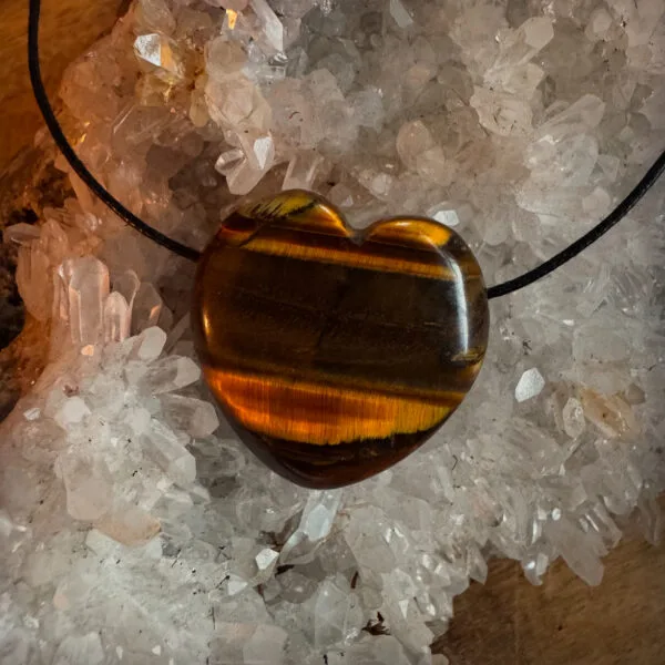Tijgeroog Hart Edelsteen Hanger - De Perfecte Balans Tussen Kracht en Bescherming Draag de kracht van de natuur dicht bij je hart met deze prachtige Tijgeroog Hart Edelsteen Hanger. Deze hanger is niet alleen een stijlvolle toevoeging aan je sieraden-collectie, maar biedt ook spirituele voordelen waar jij als hondenliefhebber én baas van kunt genieten. De Tijgeroog Hart Edelsteen Hanger wordt geleverd aan een zwart verstelbaar waskoord. Waarom kiezen voor een Tijgeroog Hart Edelsteen Hanger? Tijgeroog staat bekend als een steen van kracht, moed en bescherming. Het helpt je in balans te blijven tijdens de drukte van het dagelijks leven met je trouwe viervoeter. Of je nu samen op avontuur gaat of geniet van een rustmoment thuis, deze edelsteen helpt je gefocust en geaard te blijven. Ontdek de kracht van Tijgeroog en versterk de band tussen jou en je trouwe metgezel. Bestel vandaag nog jouw Tijgeroog Hart Edelsteen Hanger en straal samen met je hond kracht en liefde uit! Werking Tijgeroog De Tijgeroog staat bekend om zijn vermogen balans te brengen, zowel in je emoties als in je energieveld. Het helpt je om je sterker en meer geaard te voelen, waardoor je met vertrouwen uitdagingen kunt aangaan. Wanneer je de Tijgeroog Hart Edelsteen  Hanger draagt, werkt de steen als een beschermend schild dat negatieve energieën op afstand houdt en je helpt om je focus te bewaren. Bovendien bevordert Tijgeroog innerlijke rust en moed, zodat je beslissingen kunt nemen vanuit kracht en helderheid. Met zijn warme, gouden glans is een Tijgeroog hanger niet alleen een krachtig spiritueel hulpmiddel, maar ook een elegant sieraad dat je uitstraling versterkt. Het is een subtiele herinnering om je innerlijke kracht te omarmen en met vertrouwen door het leven te gaan. Geef een edelsteen cadeau De Tijgeroog Hart Edelsteen Hanger is niet alleen voor jezelf, maar ook een prachtig en betekenisvol cadeau voor een andere hondenliefhebber. Of het nu gaat om een verjaardag, een speciale gelegenheid, of gewoon een blijk van waardering – met het Tijgeroog Hart Edelsteen Hanger geef je altijd een persoonlijk cadeau. Tip: Combineer de Tijgeroog Hart Edelsteen Hanger met een van onze edelsteen halsband hangers voor je hond, zodat jullie samen een beschermende en stijlvolle energie uitstralen. Let op: Elke steen is uniek. De kleur kan afwijken en de steen kan oneffenheden bevatten. Het is een natuurproduct en is daarom niet 100% egaal. De foto's zijn ter indicatie, je ontvangt een soortgelijk product.  Edelstenen voor hondenliefhebbers – Balans en Energie voor jou en je hond Bij A Lot for Doodles draait alles om de band tussen jou en je hond. Daarom bieden we niet alleen producten voor jouw viervoeter, maar ook een unieke collectie edelstenen speciaal voor hondenliefhebbers. Edelstenen staan bekend om hun rustgevende en versterkende energieën, en zijn perfect om balans en harmonie te brengen in jouw leven én dat van je hond. Waarom Edelstenen voor de Hondenbaasjes? Persoonlijke energie en rust: Edelstenen kunnen helpen om stress te verminderen, focus te bevorderen en positieve energie aan te trekken. Perfect voor hondenbaasjes die hun dagelijkse routine met extra balans willen verrijken. Symbolische verbinding: Kies een edelsteen die aansluit bij jouw persoonlijkheid of jouw band met je hond. Denk aan stenen die liefde, bescherming of intuïtie versterken – kwaliteiten die je ook in je relatie met je hond terugziet. Draagbaar en decoratief: Gebruik de edelstenen als accessoire, zoals een hanger of armband, of geef ze een plekje in je huis. Zo draag je altijd de energie van de steen bij je of creëer je een rustgevende sfeer in je omgeving. Populaire Edelstenen Rozenkwarts: De steen van liefde en harmonie, perfect om de band met je hond te versterken. Amethist: Bekend om zijn kalmerende eigenschappen, ideaal voor ontspanning na een lange dag. Labradoriet: Voor intuïtie en bescherming, een prachtige keuze voor baasjes die bewust leven.   Een Cadeau voor jou én je Hond Onze edelstenen zijn zorgvuldig geselecteerd om jou en je hond te ondersteunen in welzijn en balans. Of je nu op zoek bent naar rust, energie of een bijzondere verbinding, er is altijd een steen die bij jou past. Bovendien zijn edelstenen een uniek cadeau, perfect om jezelf of een mede-hondenliefhebber mee te verrassen. Ontdek de kracht van edelstenen en verrijk je leven én dat van je hond. Bestel vandaag nog en geniet van de energie die deze prachtige stenen in jouw wereld brengen! Volg A Lot for Doodles op Instagram Blijf altijd op de hoogte van de leukste producten voor jouw hond. Volg ons op Instagram en Facebook. Bestel edelstenen hangers bij A Lot for Doodles Bestel je edelstenen hangers eenvoudig bij A Lot for Doodles. Heb je vragen over onze producten of advies nodig? Neem gerust contact met ons op, we helpen je graag verder. Disclaimer: - Edelstenen zullen bij veel klachten ondersteunen, maar kunnen geen medische behandeling of medicatie vervangen. Ga bij klachten altijd naar een arts.